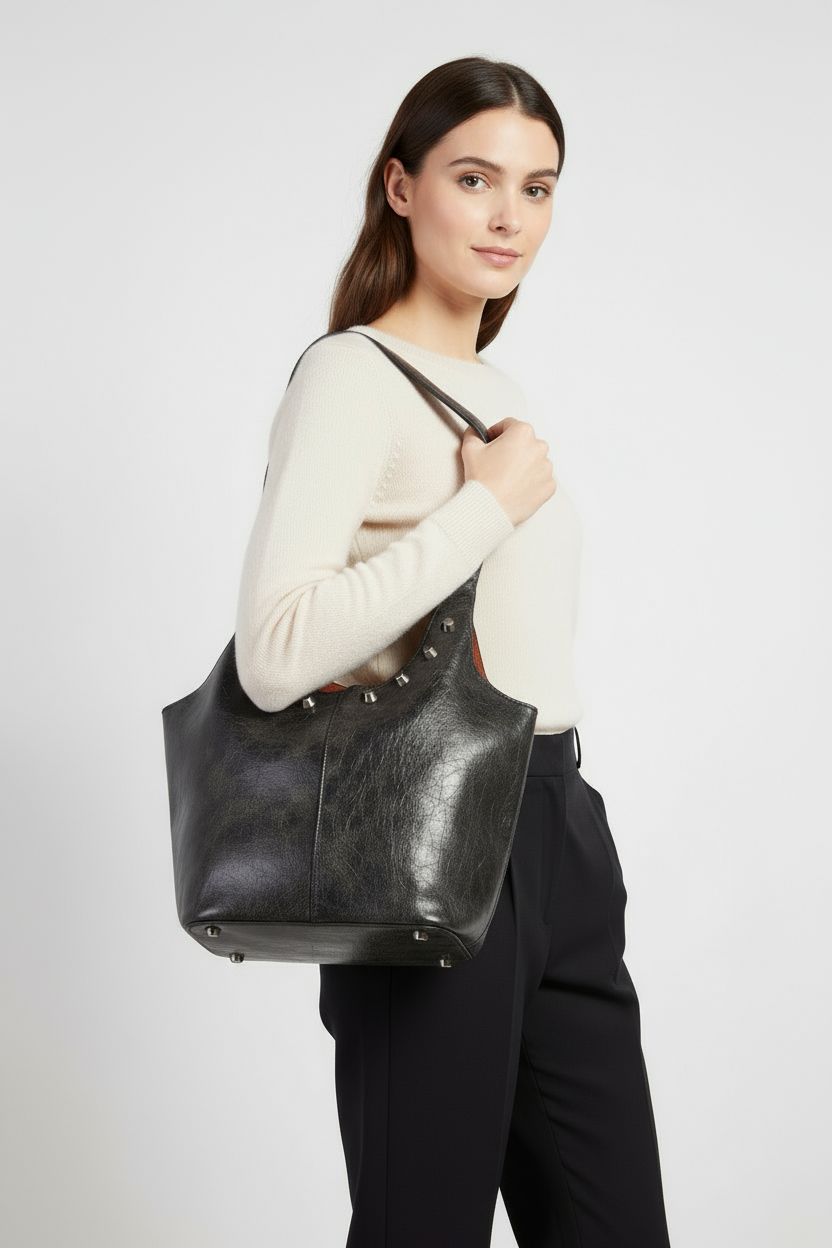 Woman holding a black leather tote bag