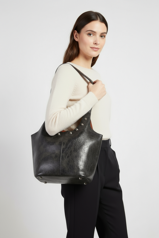 Woman holding a black leather tote bag
